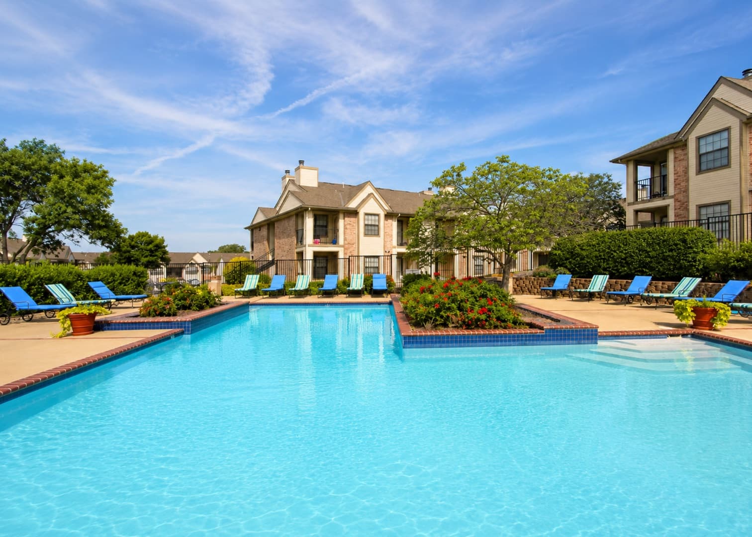 Greens At Alvamar resort-style pool with apartment buildings behind