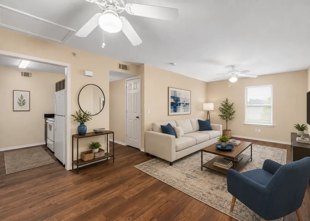 Staged living room with kitchen view, hardwood floors, and modern furnishings